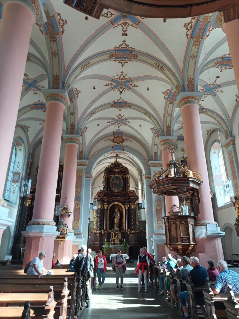 Blick auf den Hochaltar mit aus Nussbaumholz mit der Skulptur des Heiligen Josef. Dieser hält das Christuskind auf dem Arm. 