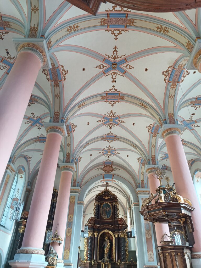 Blick auf den Hochaltar mit aus Nussbaumholz mit der Skulptur des Heiligen Josef. Dieser hält das Christuskind auf dem Arm. 