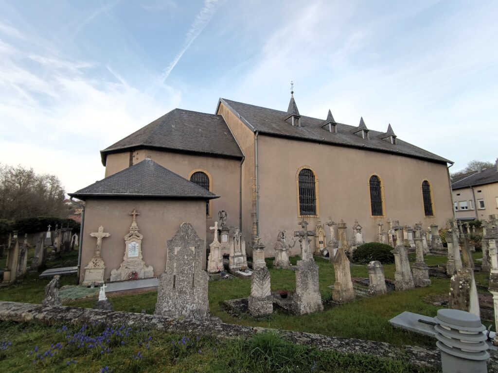 Außenansicht der Église St Rémy mit angrenzendem Friedhof in Kédange-sur-Canner.