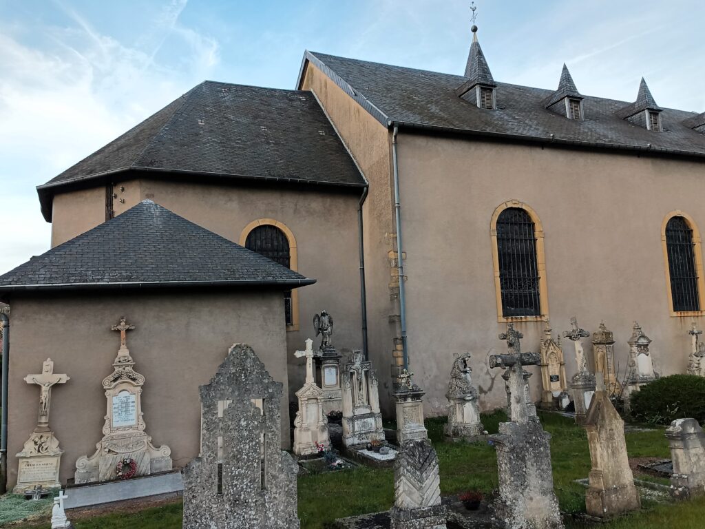 Historische Grabsteine und Denkmäler auf dem Friedhof der Église St Rémy in Kédange-sur-Canner.