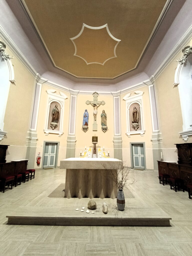 Die Apsis der Église St Rémy in Kédange-sur-Canner, mit Kruzifix und flankierenden Statuen.